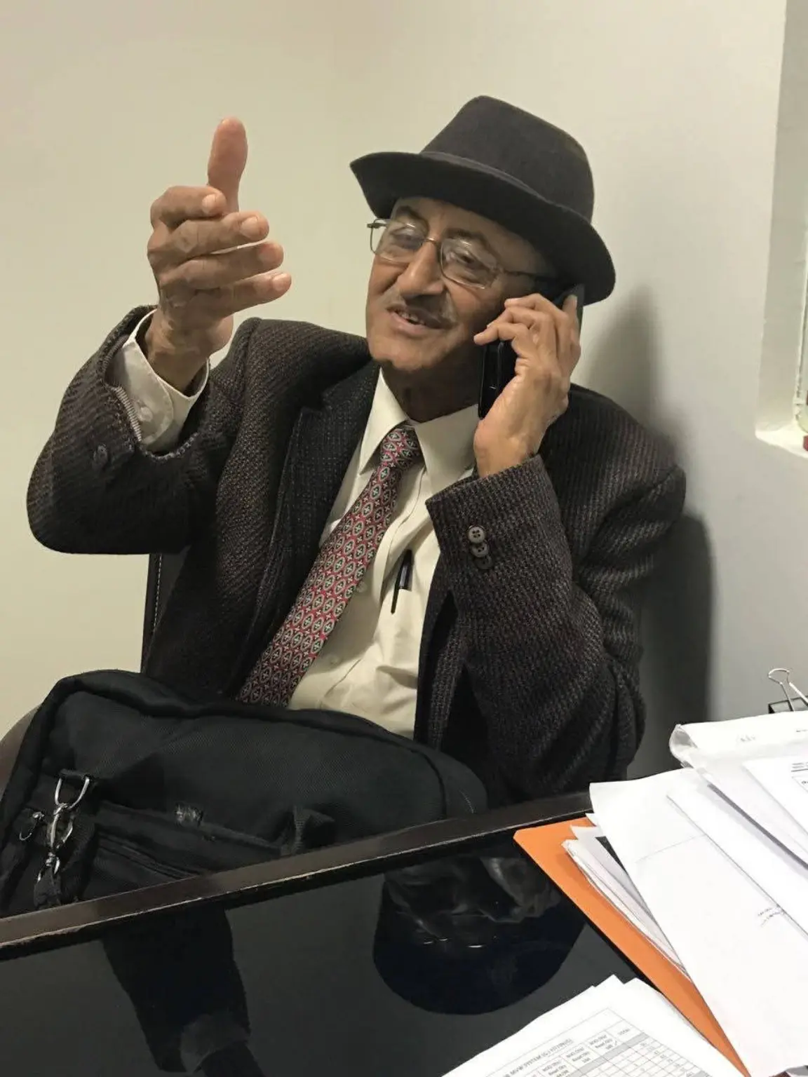 Rabboo Joshi smiling and gesturing while speaking on the phone