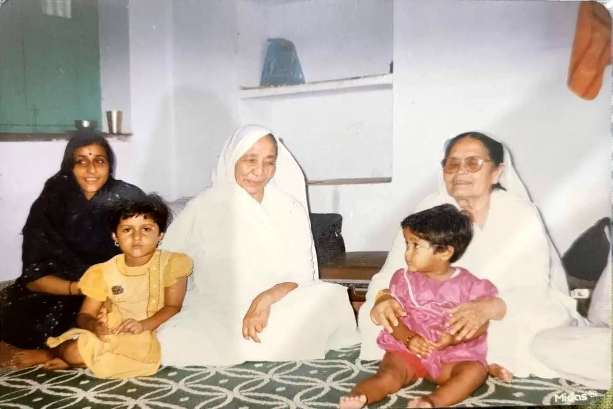 Sumati as a child seated on Choti Ma’s lap, with her mother and sister seated beside Ma