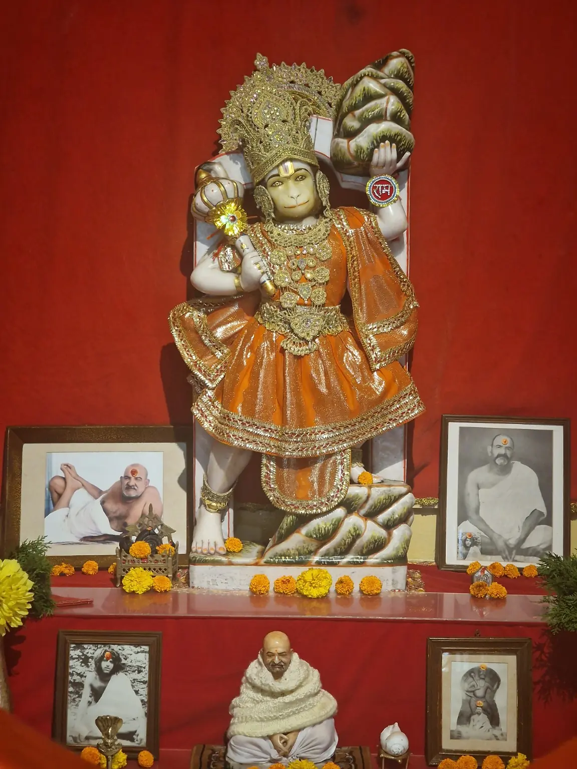 Hanumanji shrine decorated with garlands, offerings and devotional portraits