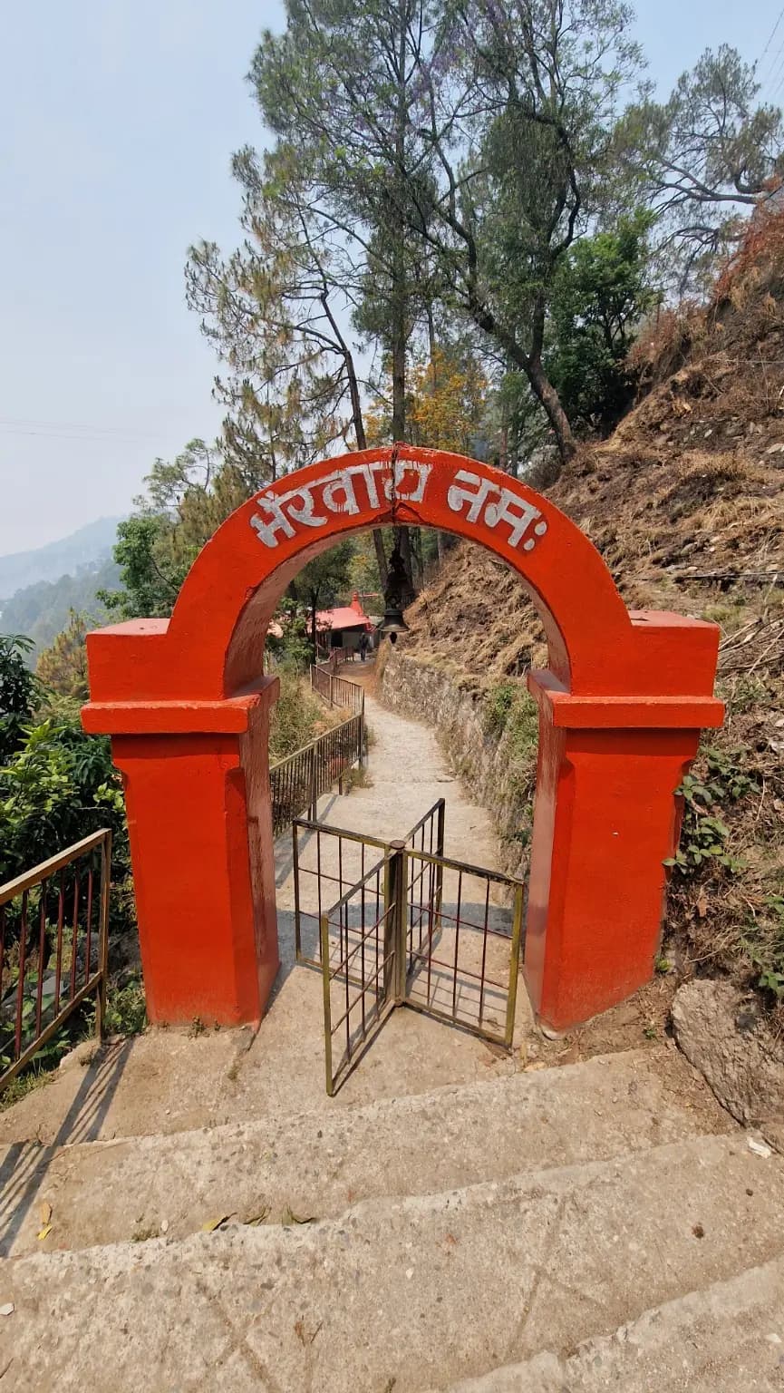 Red shrine entrance set into a wooded hillside