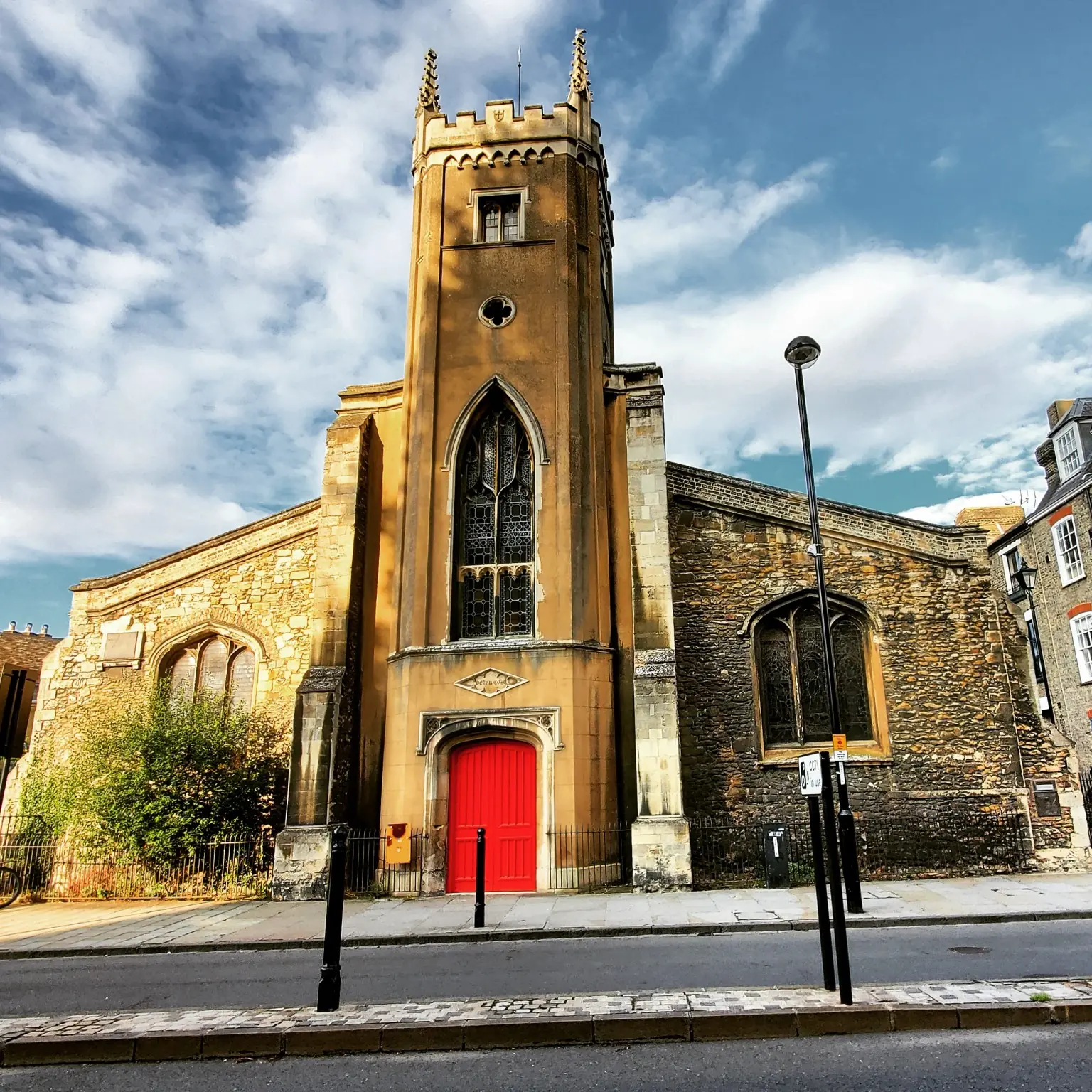 Stone church with a vivid red door beneath a blue sky